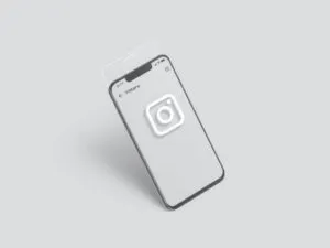 A smartphone with a white screen displays a large Instagram logo in the center. The phone floats above a light grey surface, suggesting Instagram strategies for ketamine clinics seeking patient attraction in a minimal, modern setting. - Ketamine
