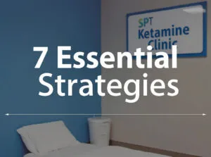 A minimalist clinic room with a single bed, a white bin, and a sign that reads 